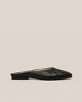 A single black leather flat mule with a pointed toe and gathered upper, shown in profile against a solid beige background.